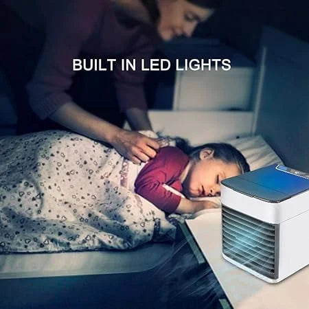Person and child lying in bed with a portable air conditioner and LED lights.