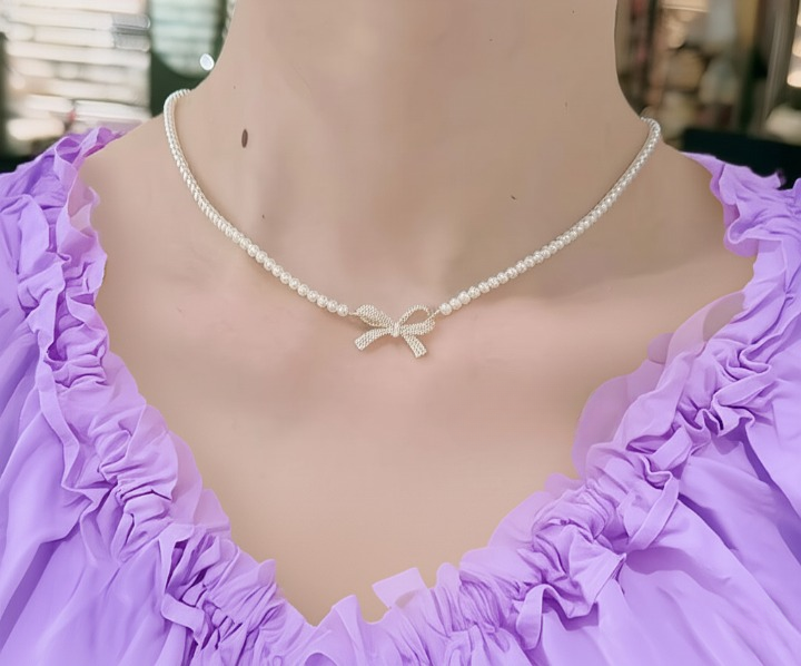 Elegant golden finish dainty jewelry necklace worn by a model