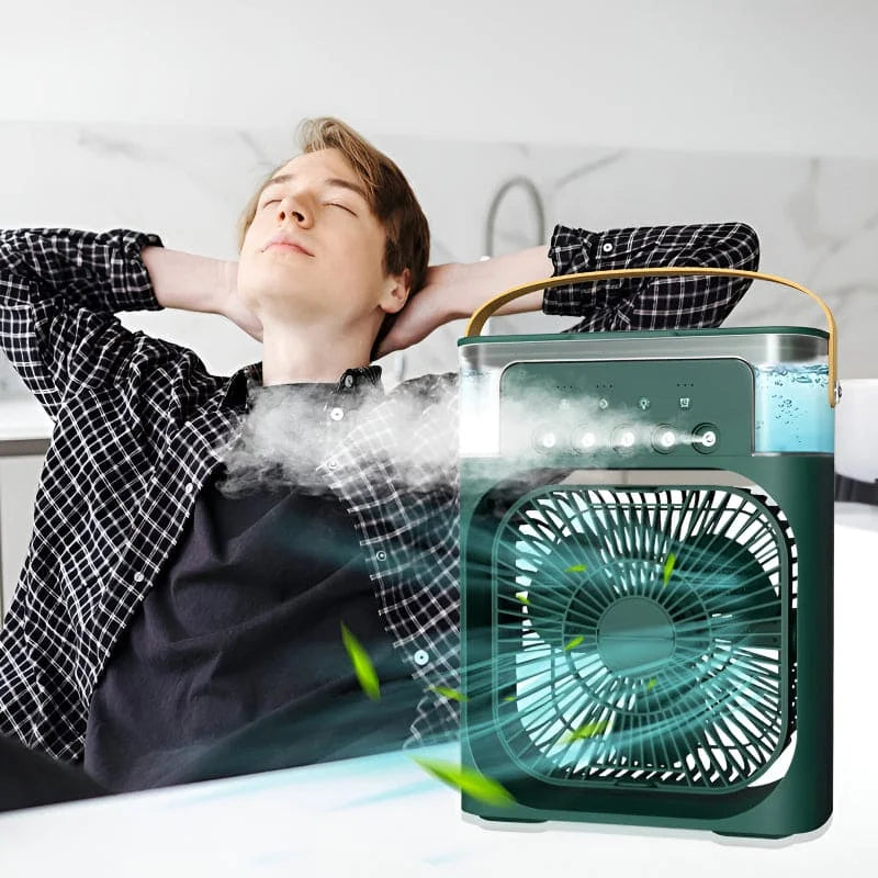 Person lying on a bed with a portable air cooler emitting mist, set against a white wall.