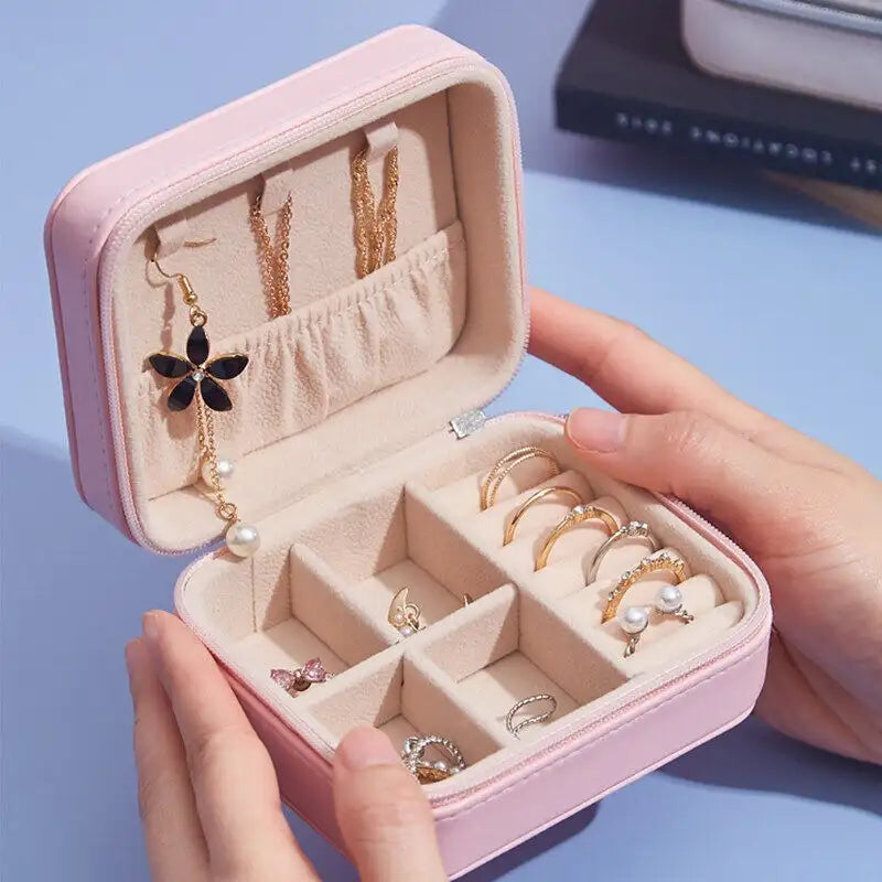 Pink jewelry box with rings and earrings on a blue background