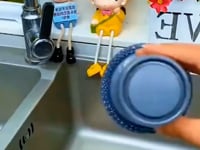 Versatile soap dispensing brush effortlessly cleaning a stainless steel kitchen sink