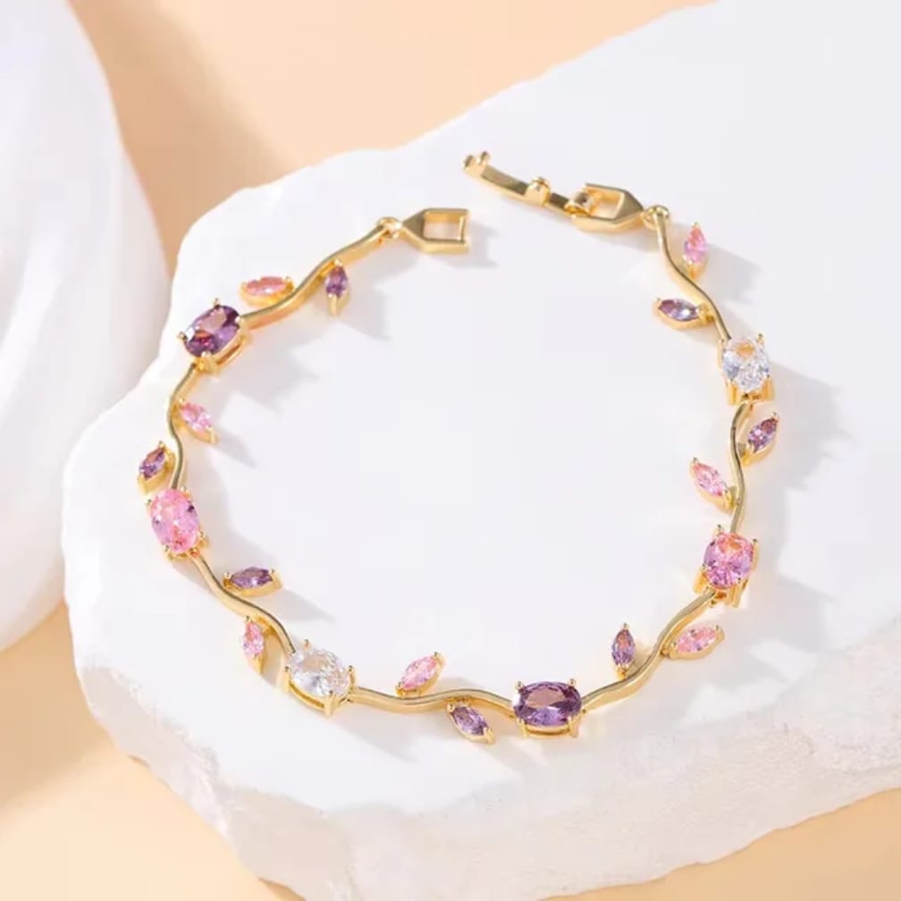  bracelet with pink and purple gemstones on a white fabric background