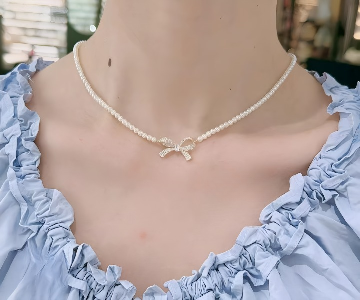 Close up of sparkling zircon stones on the golden finish bow pendant